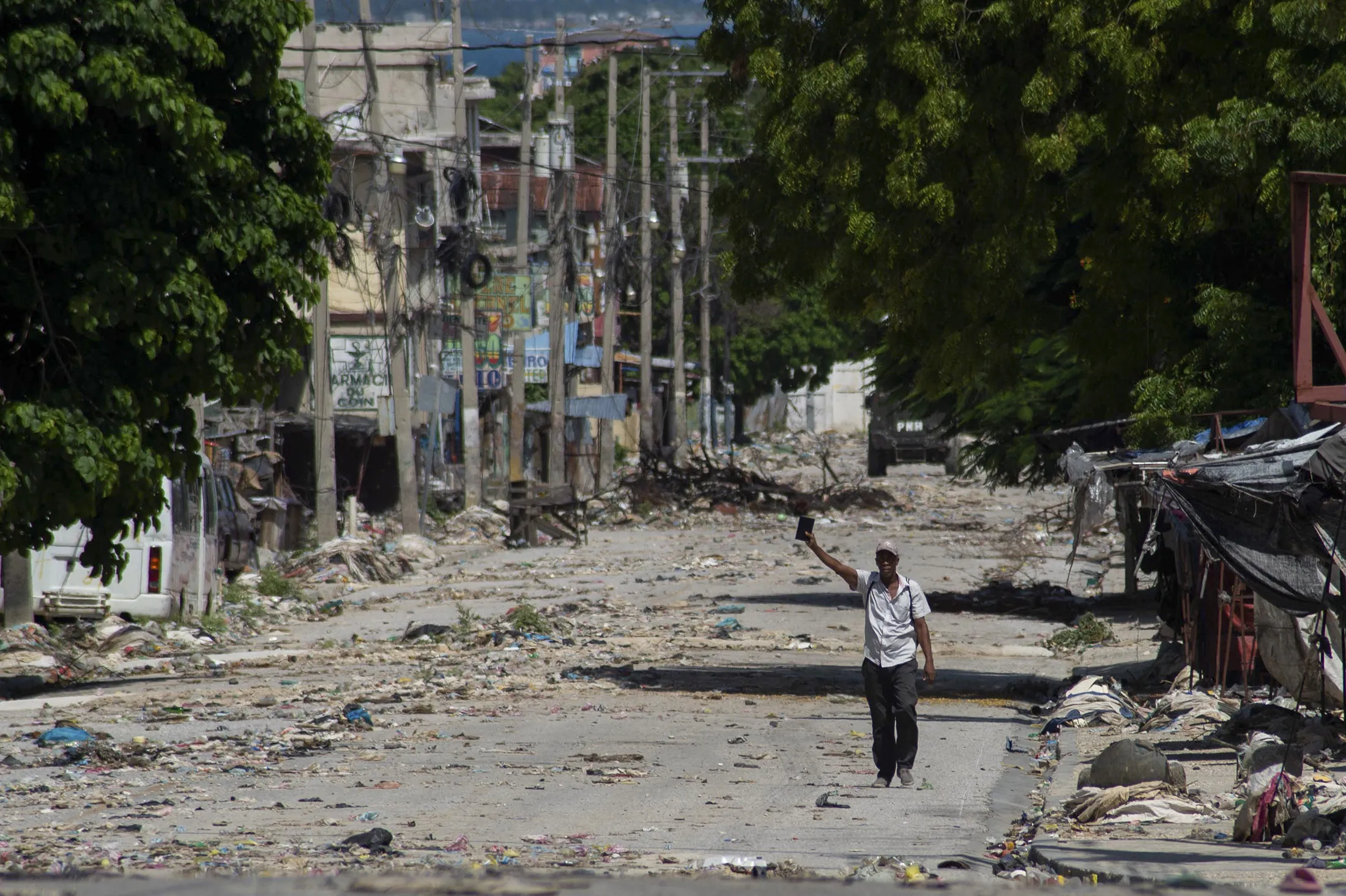 A man holds a Bible on a deserted road near the Presidential Palace and a military garrison in downtown Port-au-Prince on June 14.