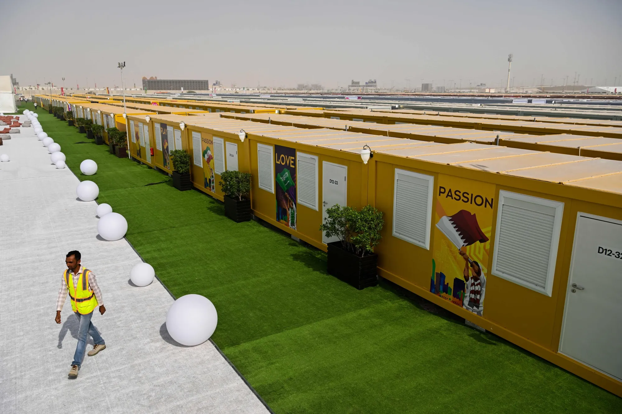 An employee walks past cabins at the Al-Emadi fan village in Doha in November 2022.