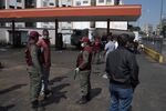 Members of the Bolivarian National Guard stand guard at a PDVSA gas station in the Petare neighborhood of Caracas, Venezuela, on March 26.