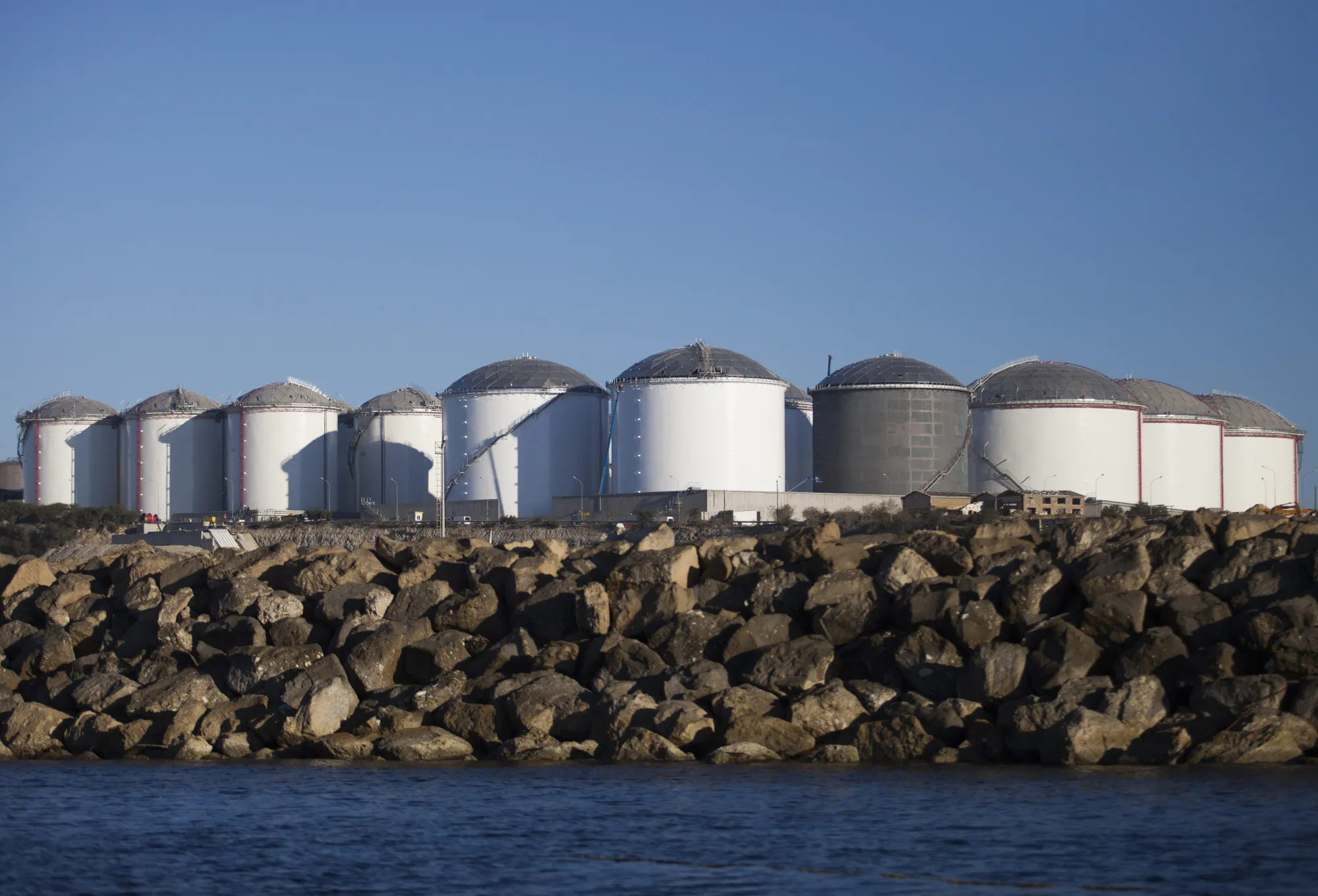 Fuel storage tanks stand on the shore at the VTTV oil storage terminal in Vasilikos, Cyprus.
