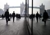 Pedestrians walk through the More London office space against the backdrop of Tower Bridge, in London.