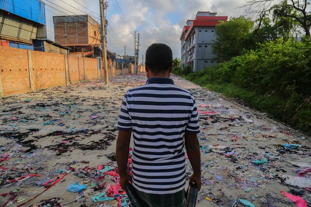 A man walks through a street full of discarded textiles near the Matuail Sanitary Landfill in Dhaka.
