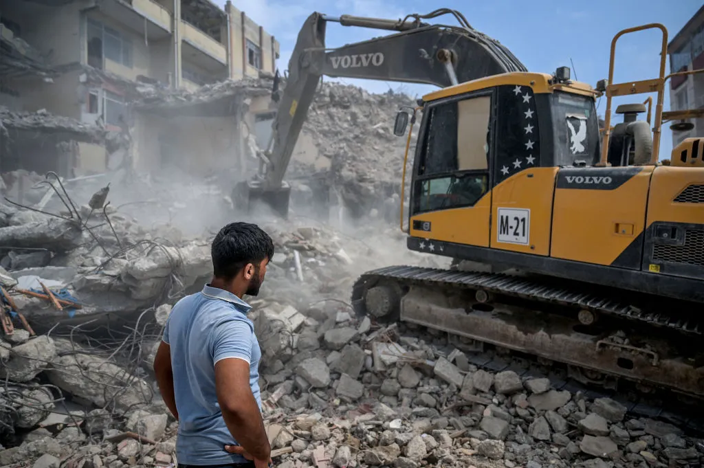 Workers move rubble of collapsed buildings following the earthquake, in Samandag,Turkey.&nbsp;