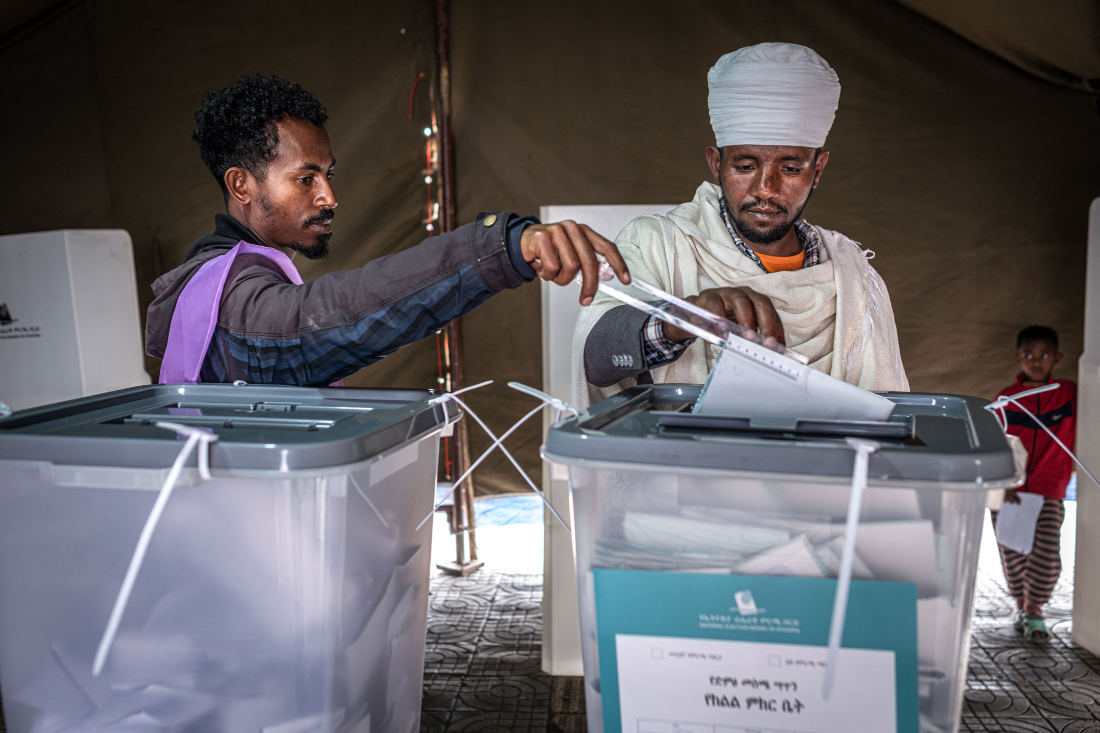 A voter casts his ballot assisted by a National Election Board of Ethiopia official at a polling station in Addis Ababa, on June 1. Photographer: Marco Simoncelli/AFP/Getty Images