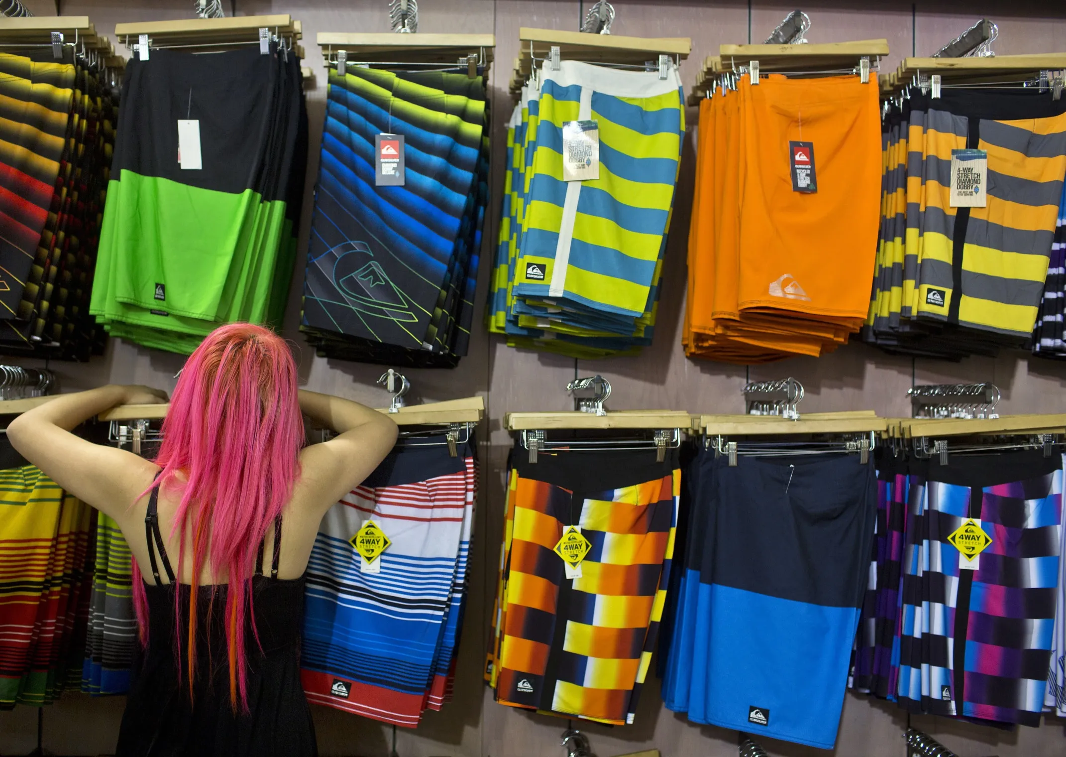 An employee arranges a display of clothing at a Quiksilver store in New York.