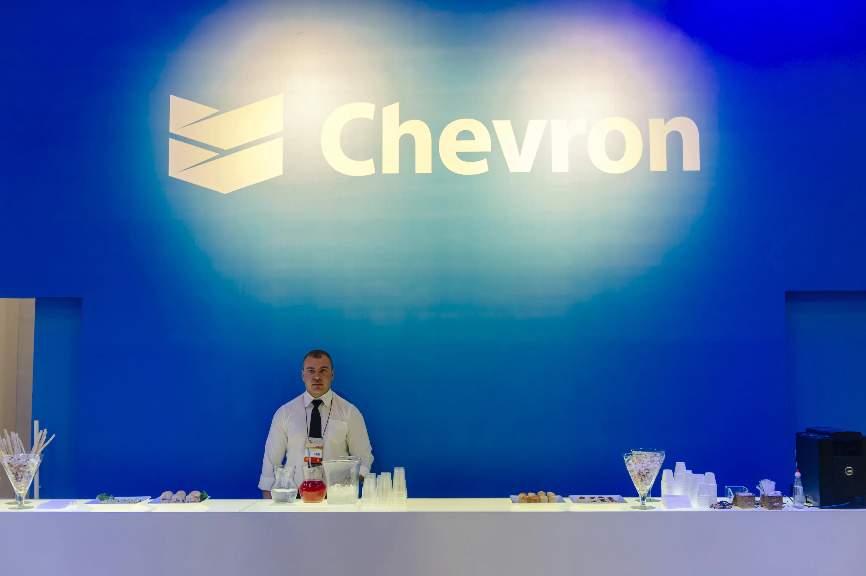 An employee stands behind a service bar at the Chevron Corp. trade stand during the Rio Oil & Gas 2014 Expo and Conference in Rio de Janeiro, Brazil, on Monday, Sept. 15, 2014. Petroleo Brasileiro SA, Brazil's state-run oil company, extended losses as an economic adviser to presidential candidate Marina Silva said she would increase a tax on gasoline if elected in next month's vote.