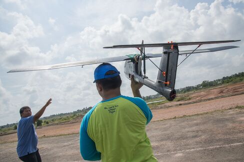 Members of the tax office prepare to launch a drone for a test flight at the Palembang military airbase complex. Photographer: Rony Zakaria/Bloomberg