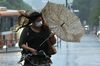 A pedestrian walk in the heavy rain and strong wind as Typhoon Talim approaches to western Japan on Sept. 17.