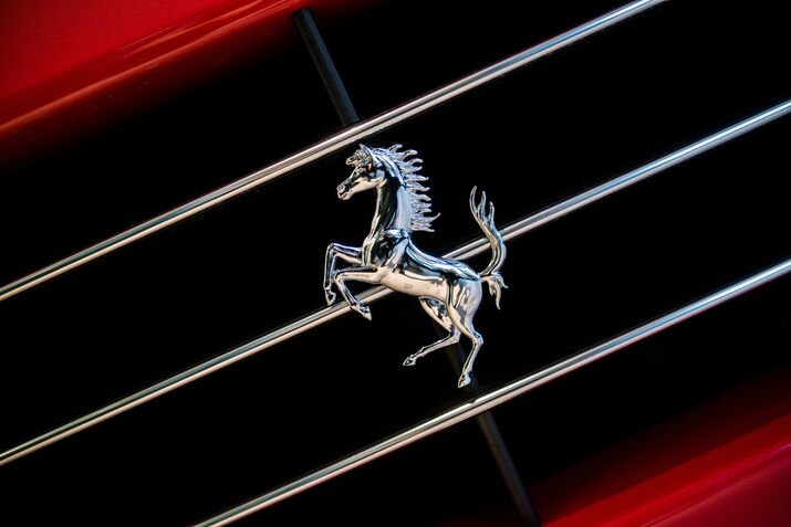 A prancing horse badge on the front grill of a Ferrari.