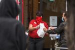 An employee hands out takeout orders to customers outside a Chick-fil-A restaurant in Brooklyn, New York on April 15.