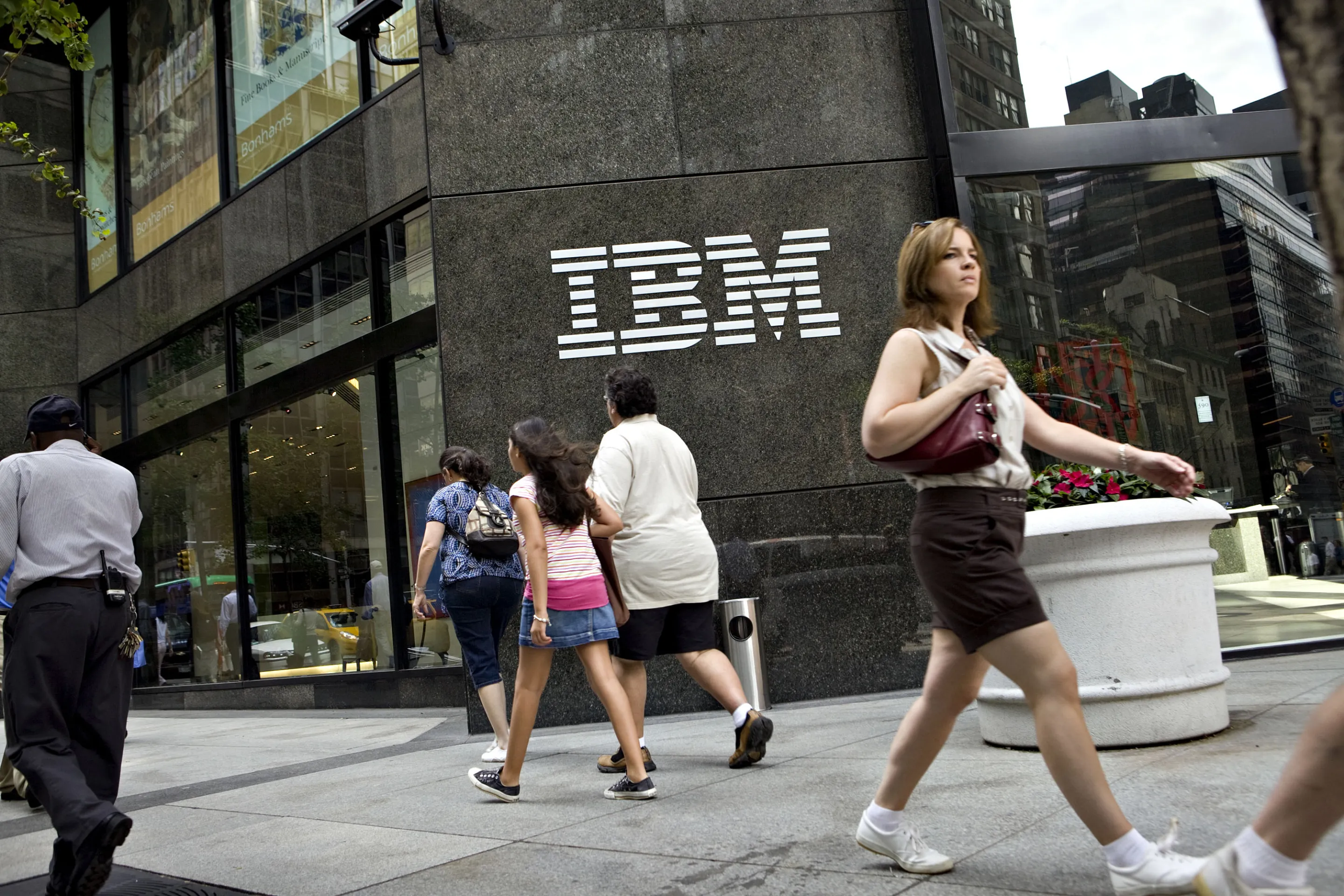 Pedestrians walk outside the IBM offices.