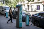 A pedestrian&nbsp;passes electric automobiles charging at Ubeeqo SAS electric vehicle charge stations in Paris, France on May 27, 2020.