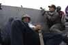 A protester takes cover behind a concrete barrier beside a National Guard member supporting Venezuelan opposition leader Juan Guaido during a military uprising near the La Carlota base.