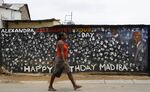 A woman in the Alexandra township of Johannesburg walks past a mural of Nelson Mandela, who lived in the township as a young man. 