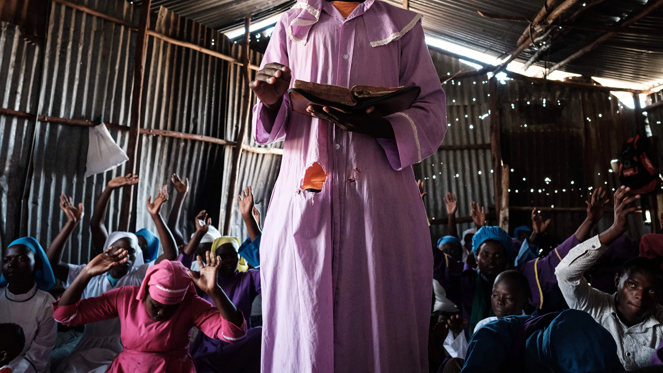 A worshipper of Adundo Messiah church reads the bible during the Sunday church service in Kisumu, on October 29, 2017. / AFP PHOTO / YASUYOSHI CHIBA (Photo credit should read YASUYOSHI CHIBA/AFP/Getty Images)
