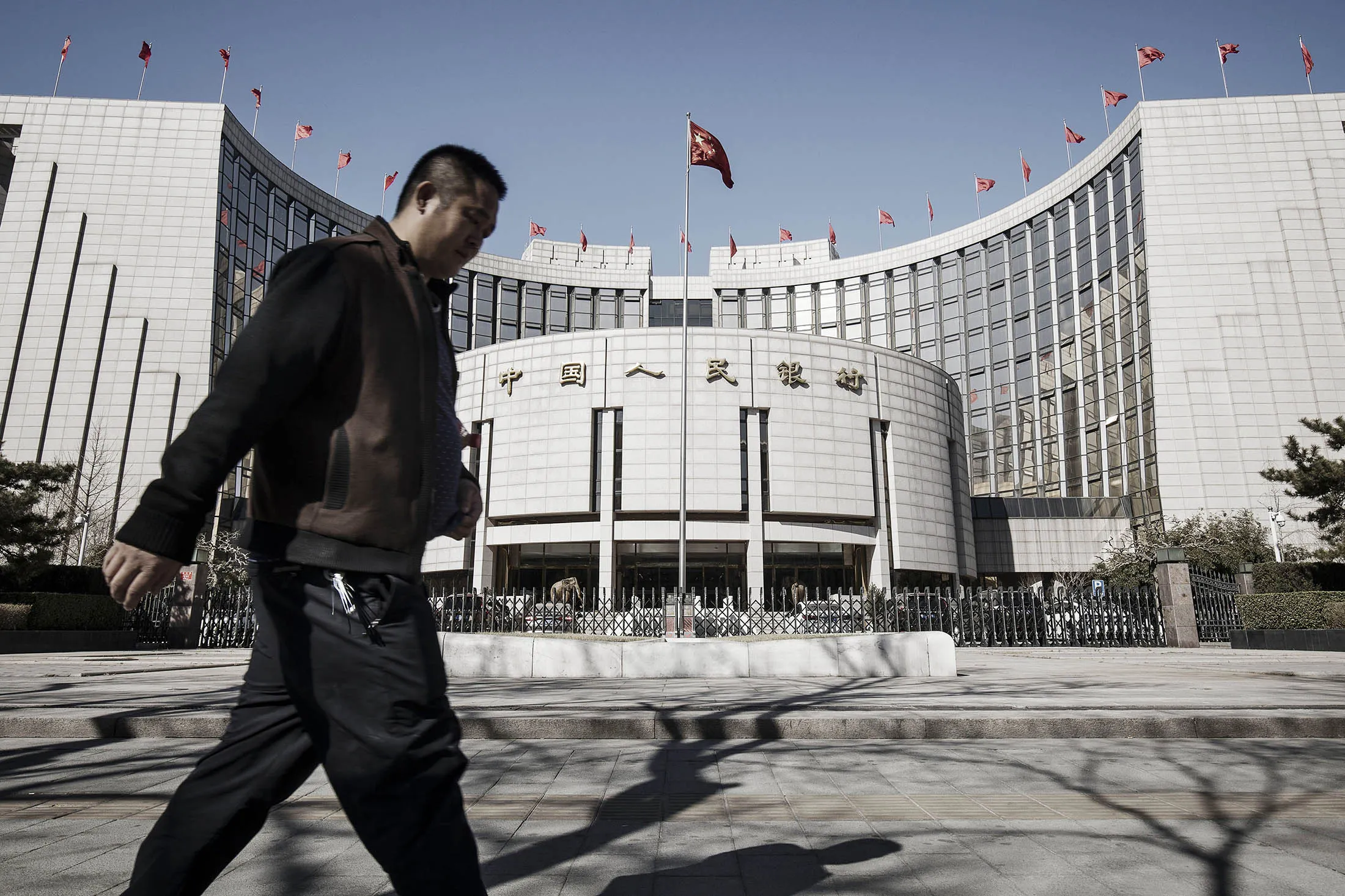 A man walks past the People's Bank of China (PBOC) headquarters in Beijing, China.
