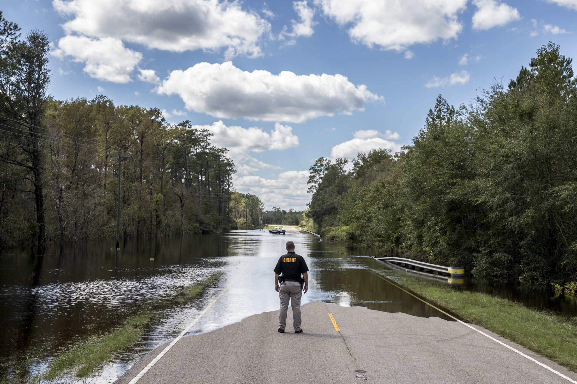 A Pender County Sheriff stands in front of a section of flooded road after Hurricane Florence hit in Currie, North Carolina, on&nbsp;Sept. 18, 2018.