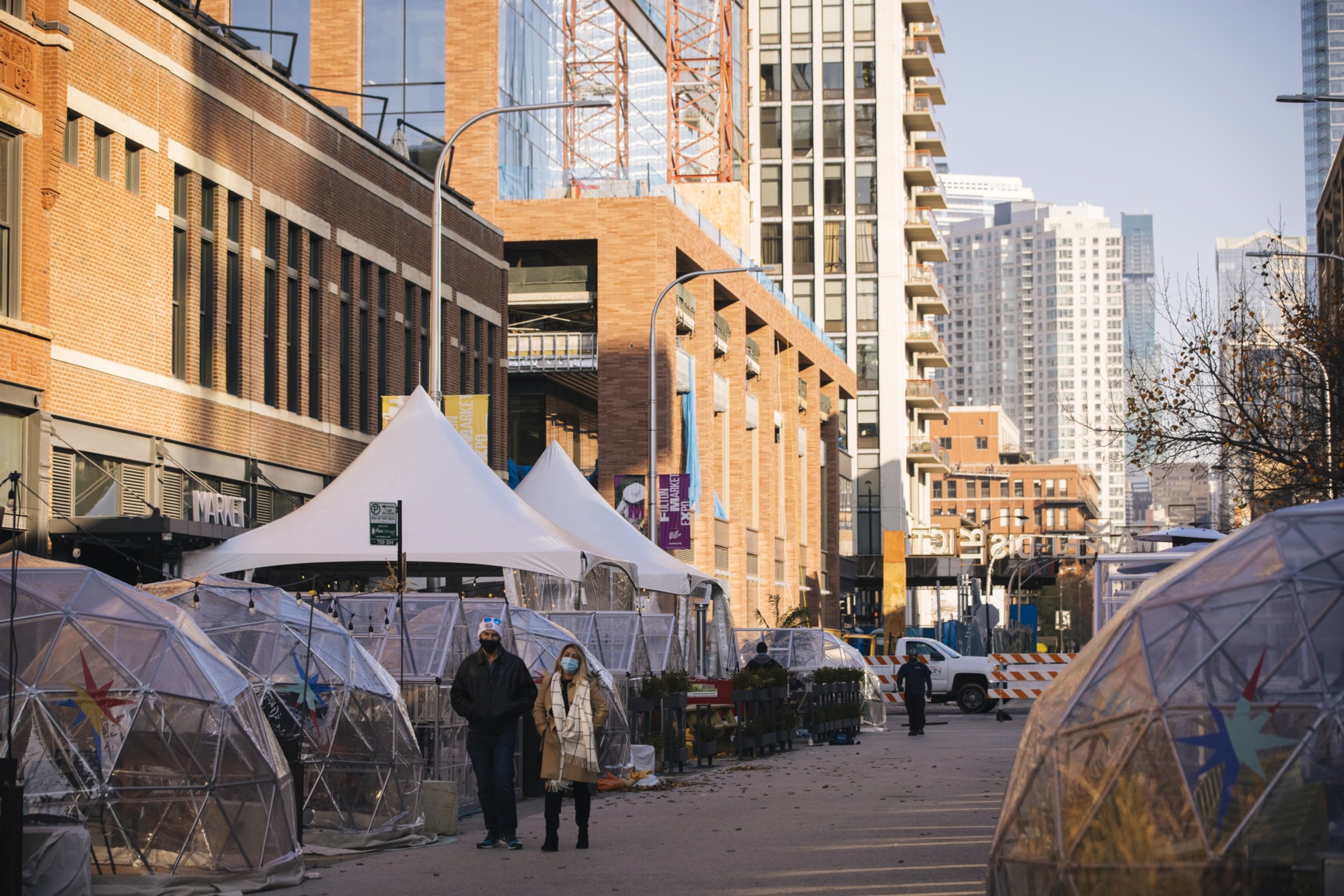 Pedestrians walk past social distancing bubble dining tents at West Fulton Market in Chicago on Nov. 13.&nbsp;
