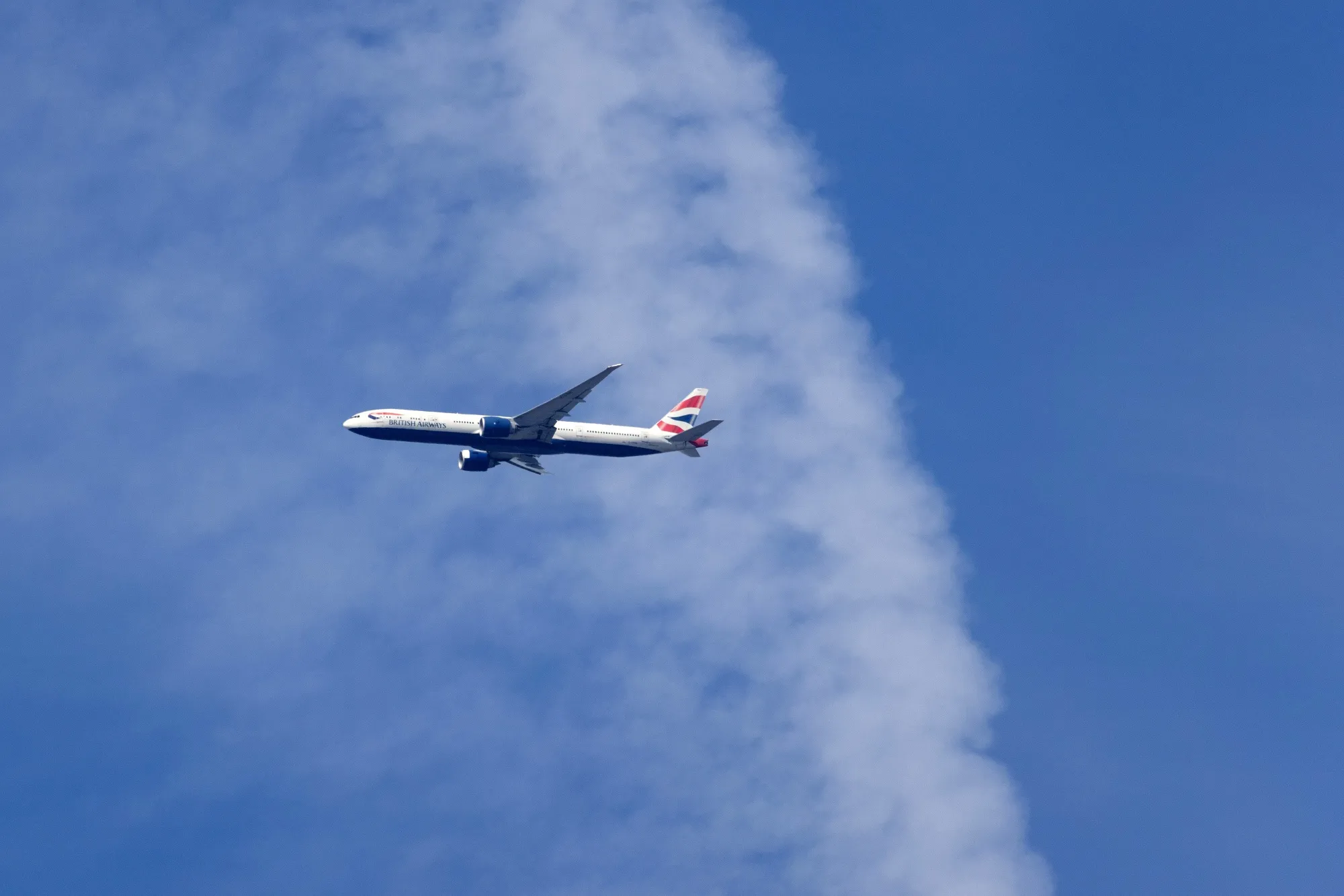 A passenger aircraft, operated by British Airways, flies above London.