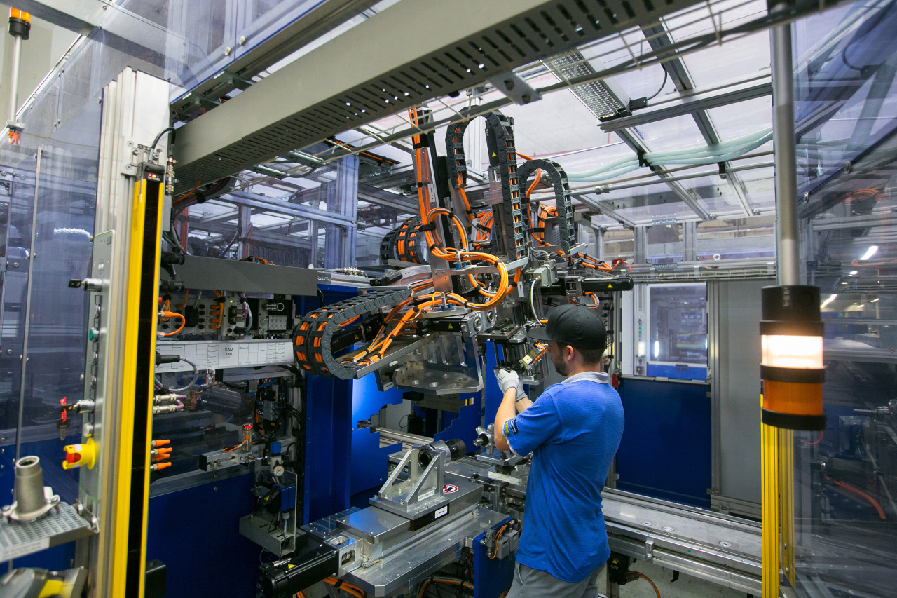 An employee operates machinery on the electronic automotive steering systems production line at ThyssenKrupp AG's Presta SteerTec factory in Mulheim, Germany.