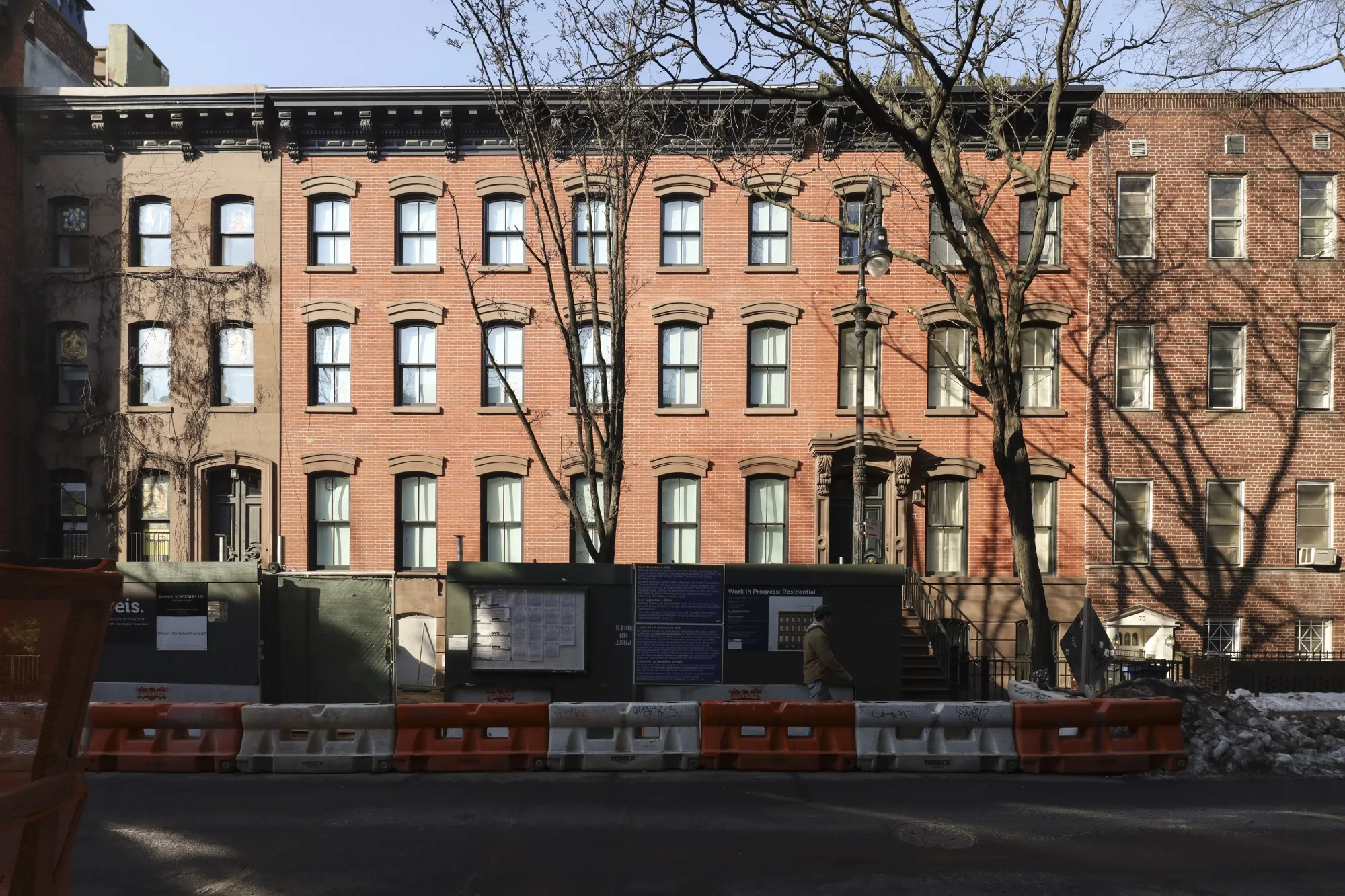 A red brick mega-mansion with construction materials in front of it.