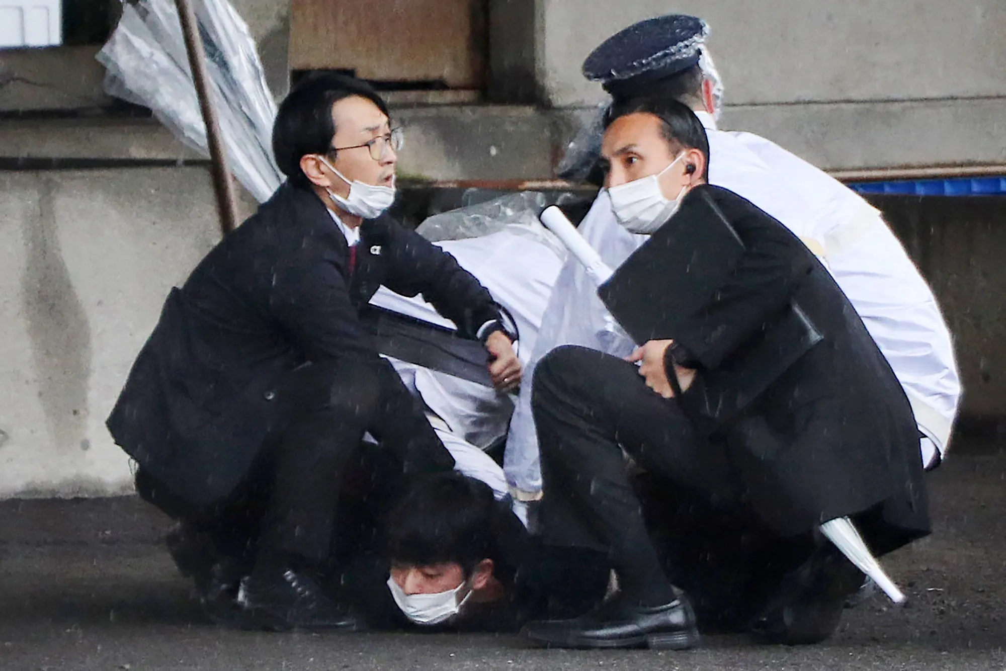 A man is detained after throwing a smoke bomb at Kishida in Wakayama on April 15.