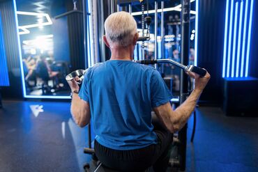 Rear view of senior man exercising in the gym. RF