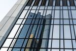The Deutsche Bank AG headquarters are reflected in the glass facade of neighboring skyscraper Trianon in Frankfurt.