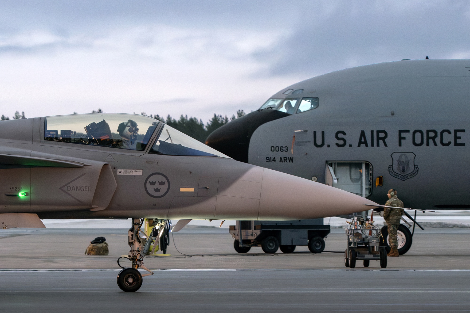 TOPSHOT - A JAS 39 Gripen C/D fighter aircraft of the Swedish Armed Forces taxis past a US KC-135 Stratotanker military tanker aircraft at Lulea-Kallax Airport, Sweden on March 4, 2024 during the NATO Nordic Response 24 military exercise, a Norwegian national exercise carried out in northern Sweden, Norway and Finland with associated airspace and waters. In order to increase the Armed Forces' military capability, Swedish units participate in the exercise, which is an integral part of the NATO exercise series Steadfast Defender, NATO's biggest military exercise since the Cold War. The Western military alliance has said some 90,000 troops will take part in the months-long Steadfast Defender 24 exercise designed to test its defences in the face of Russia's war on Ukraine. Steadfast Defender will be composed of a series of smaller individual drills and will span from North America to NATO's eastern flank, close to the Russian border. (Photo by Anders WIKLUND / TT News Agency / AFP) / Sweden OUT (Photo by ANDERS WIKLUND/TT News Agency/AFP via Getty Images) Photographer: ANDERS WIKLUND/AFP