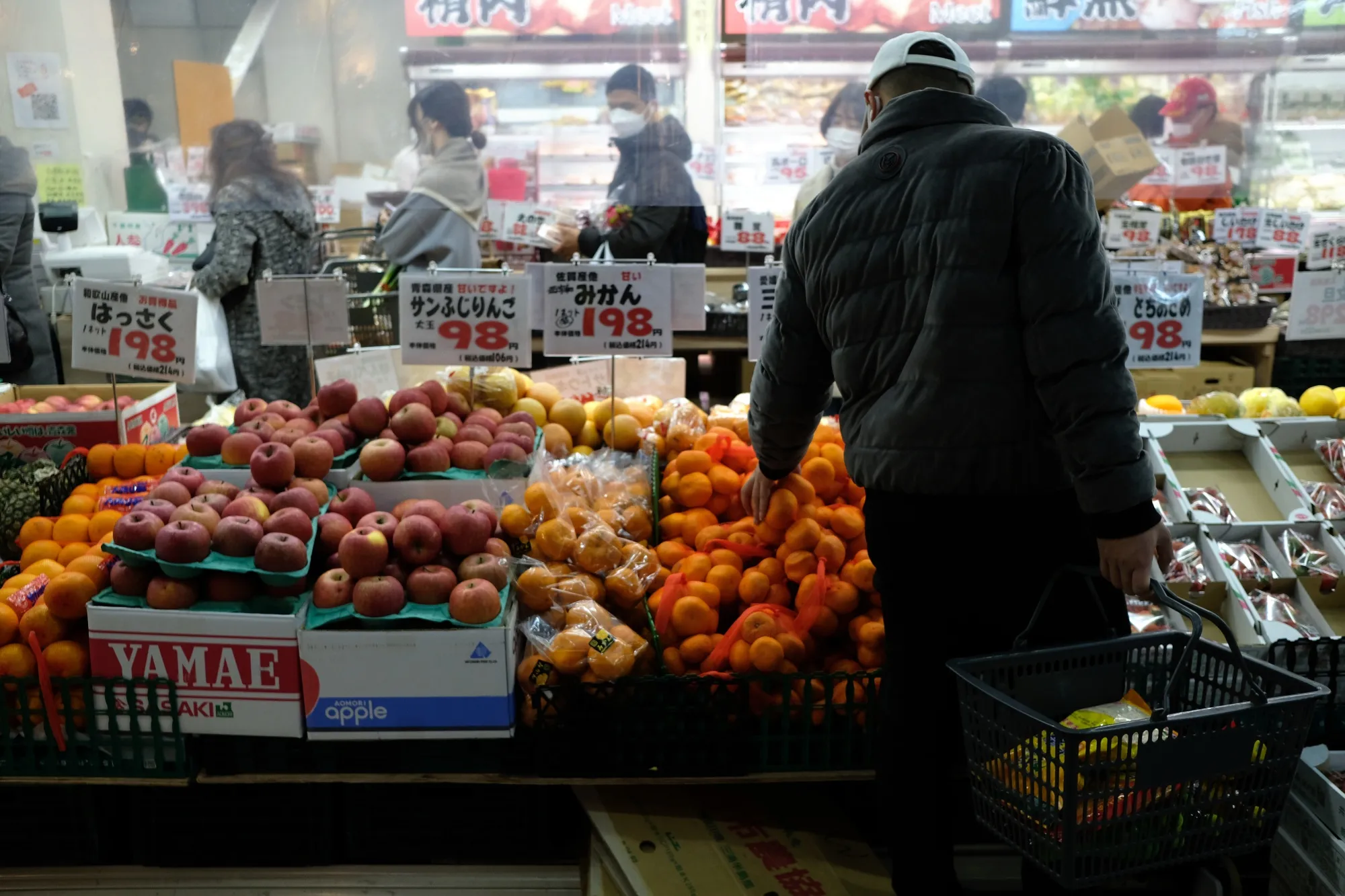 A customer purchases oranges at a store in the Ota district of Tokyo, Japan.