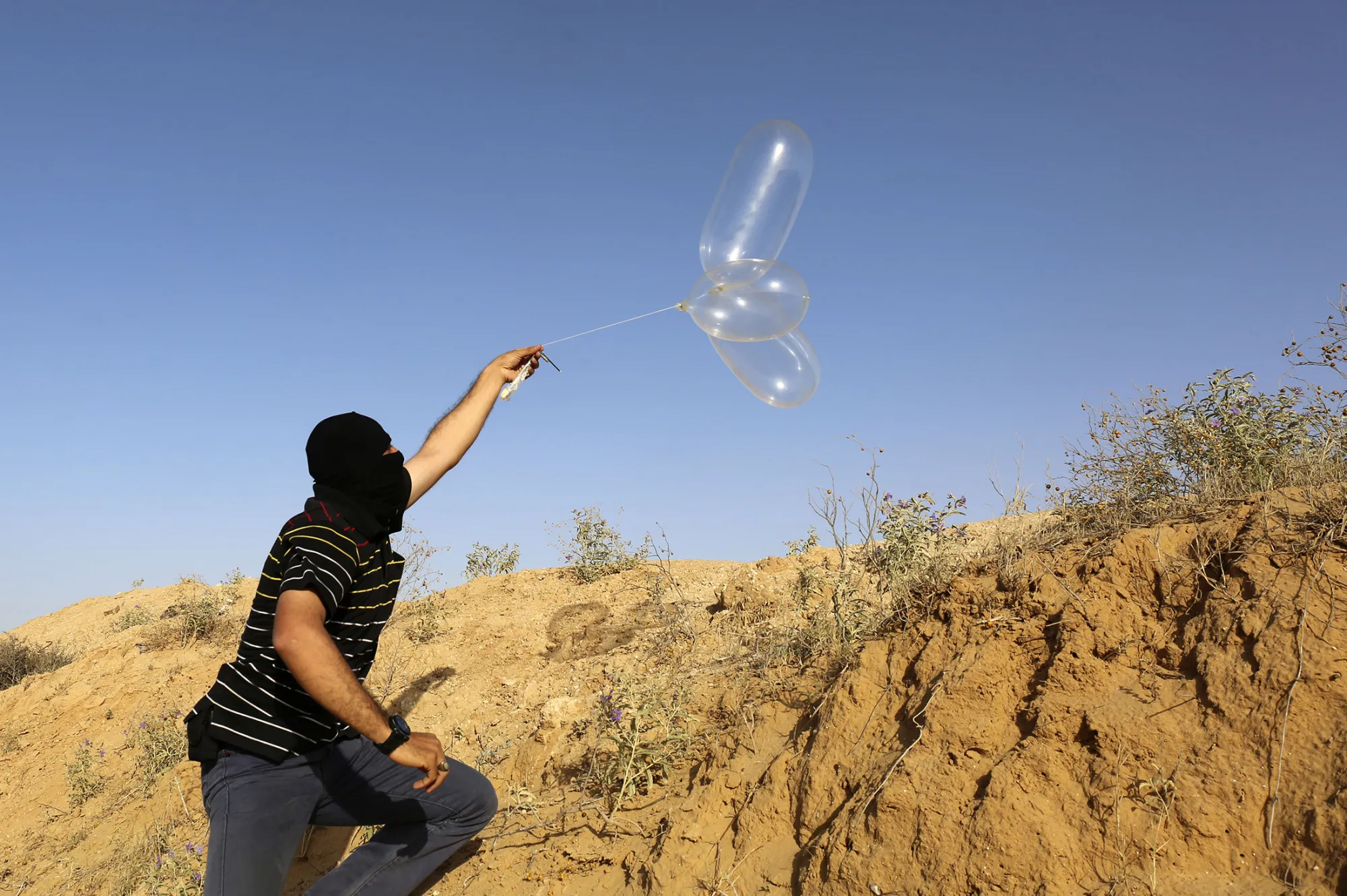 A &nbsp;Palestinian launches a balloon loaded with flammable material in Rafah&nbsp;on June 17.