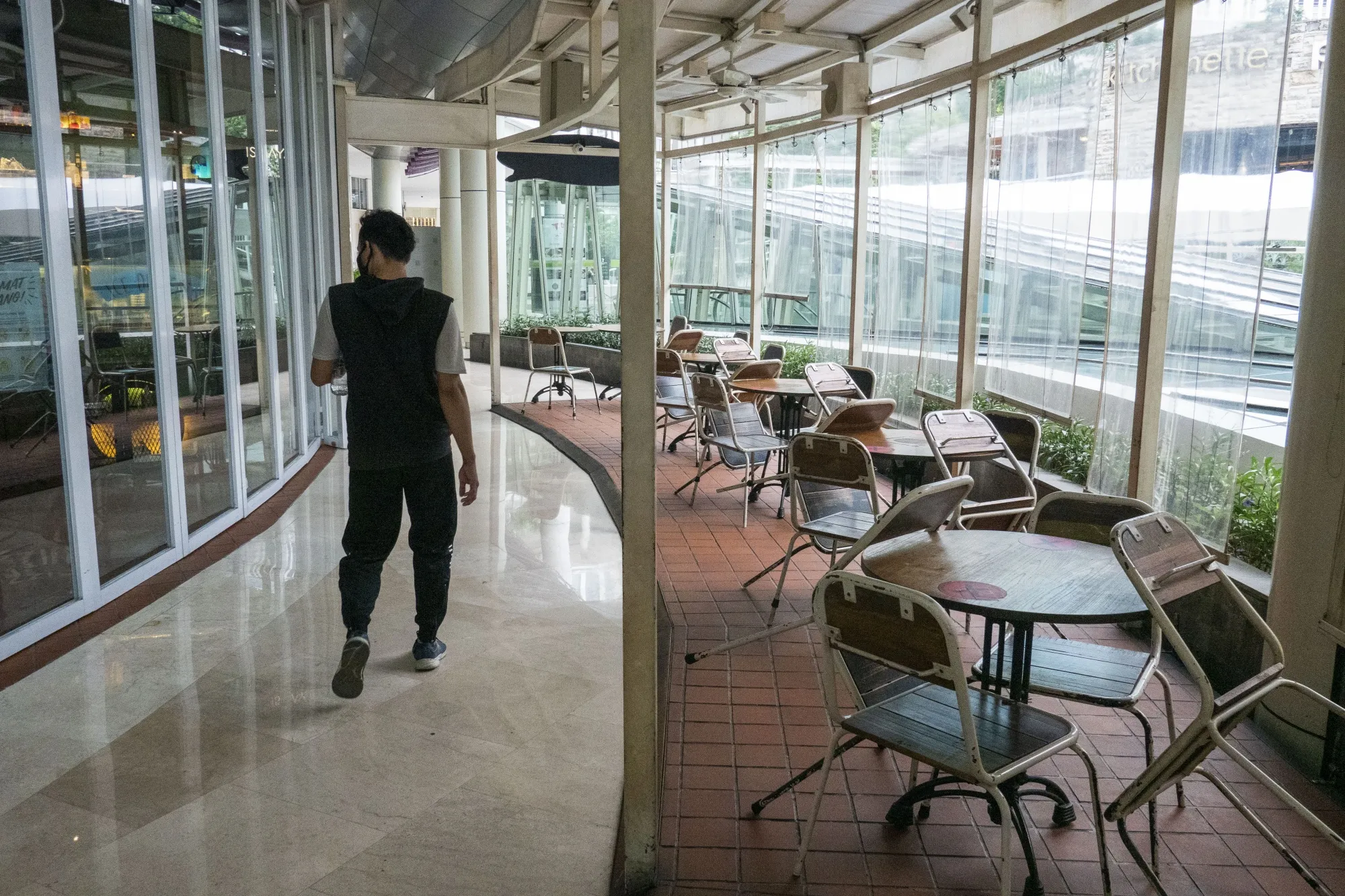 A visitor passes a closed restaurant inside a shopping mall during a partial lockdown due to the coronavirus in West Jakarta, Indonesia, on Monday, Sept. 14, 2020. Jakarta is requiring non-essential industries to have their employees work from home, limit the use of public transportation, as well as shut entertainment sites and places of worship starting Sept. 14.