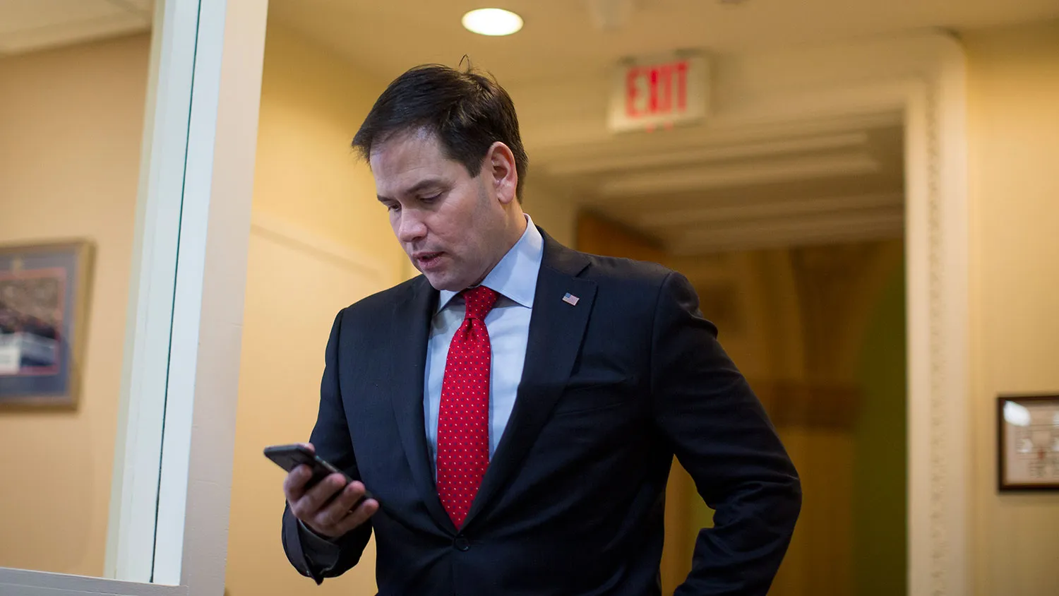 Sen. Marco Rubio (R-FL) checks his mobile phone as he arrives for a news conference to introduce a proposal for an overhaul of the tax code, March 4, 2015 on Capitol Hill in Washington, DC.

