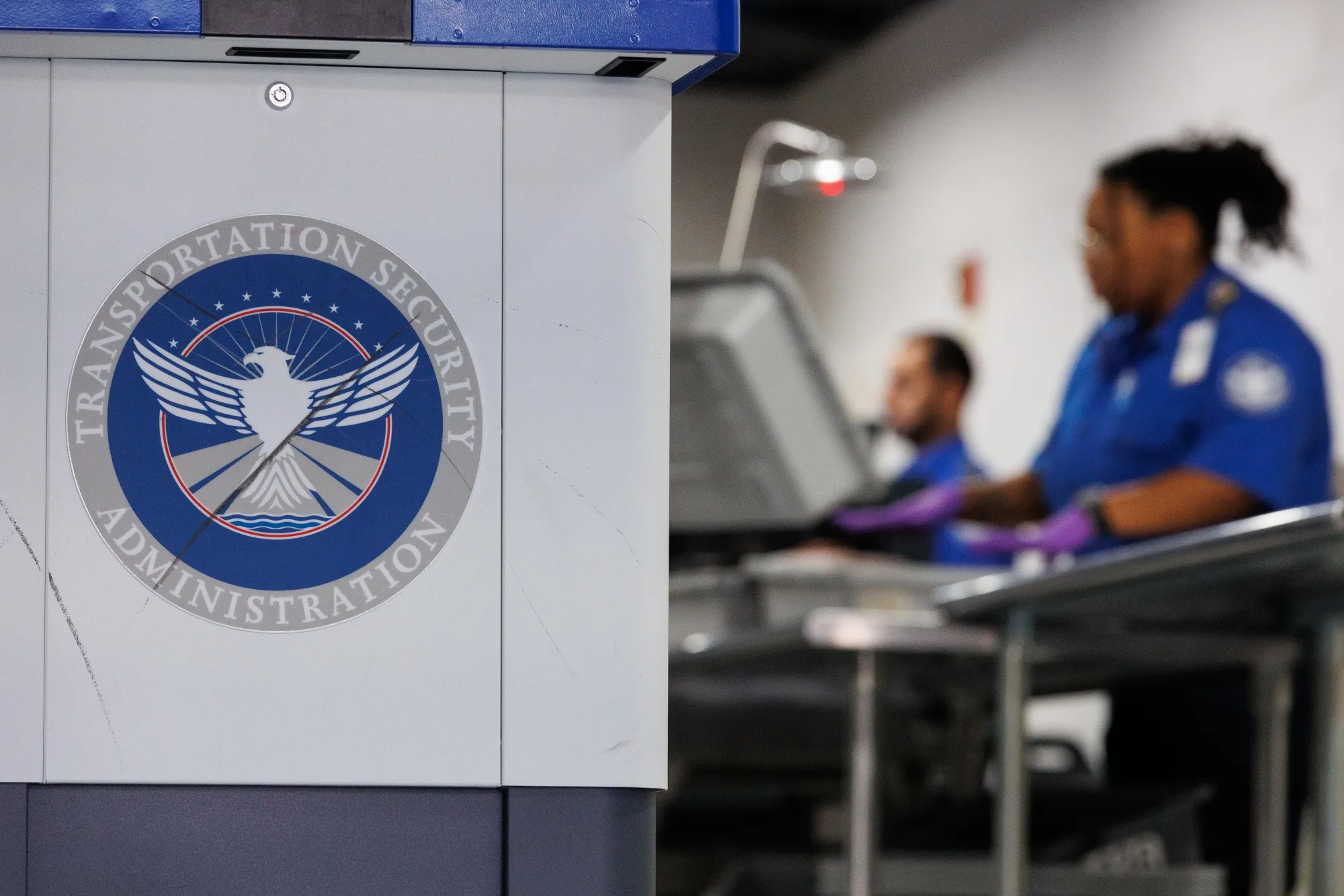 TSA agents at a security checkpoint at Dallas-Fort Worth International Airport.