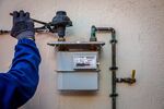 A gas technician installs a gas meter at a residential apartment in Corbera De Llobregat, Spain.