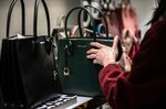 A shopper looks at a Michael Kors Holdings Ltd. handbag on display at the Macy's Inc. flagship store in New York.