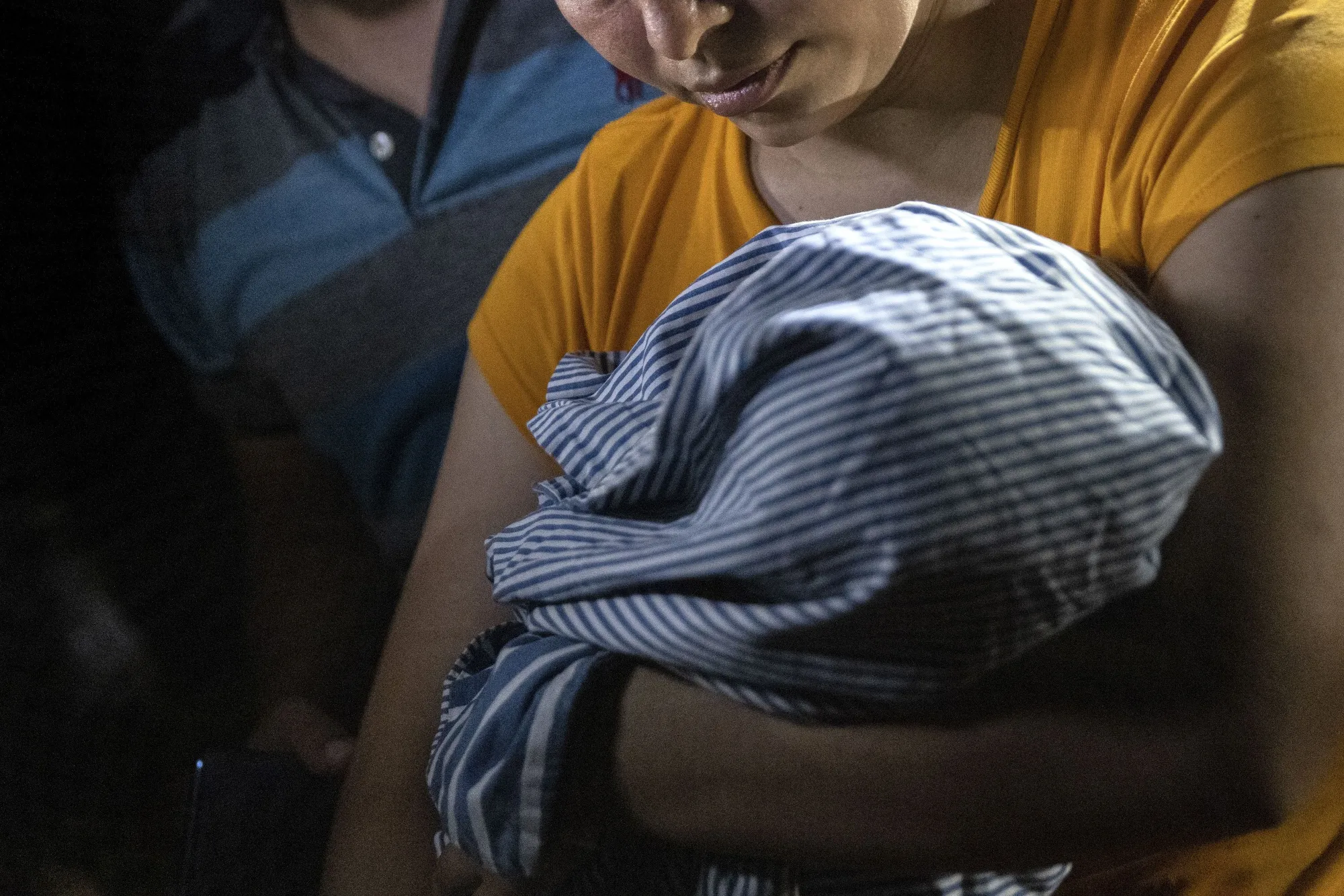 Immigrant parents hold their infant at the US-Mexico border.