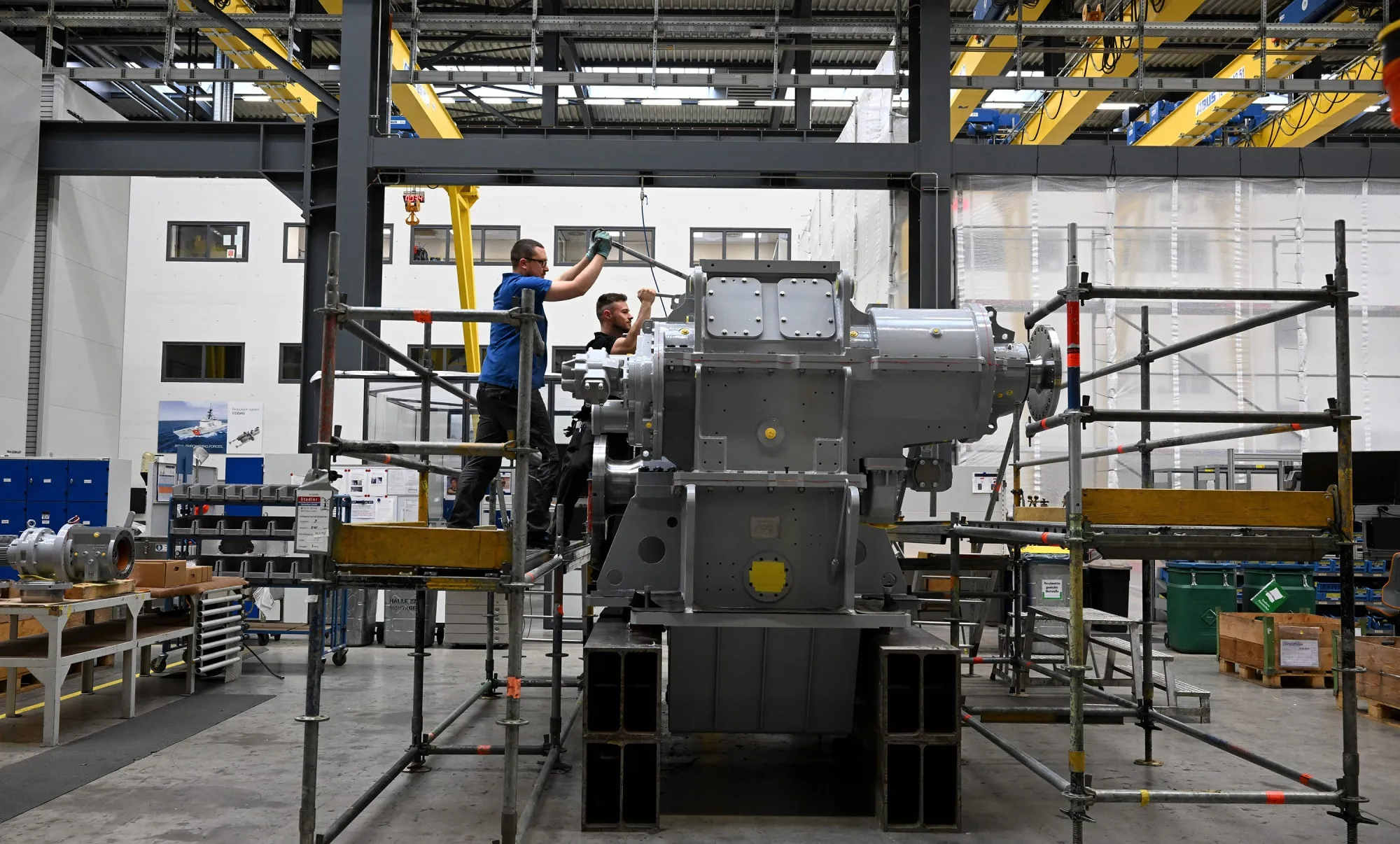 Employees work at a ship gear at a Renk facility in Augsburg, Germany.