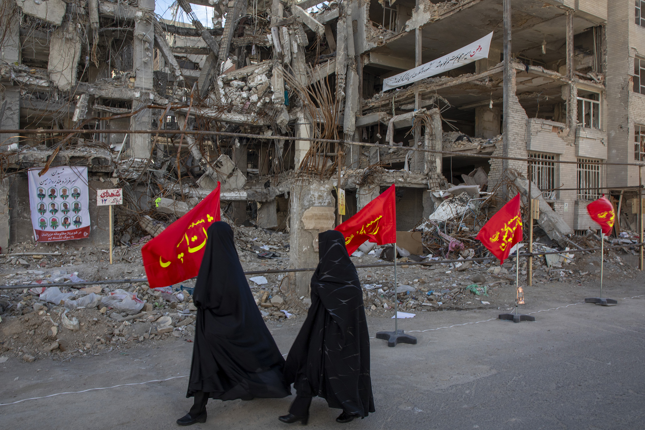 Women walk past buildings destroyed by strikes in Tehran, Iran, on April 6, 2026. Photographer: Majid Saeedi/Getty Images