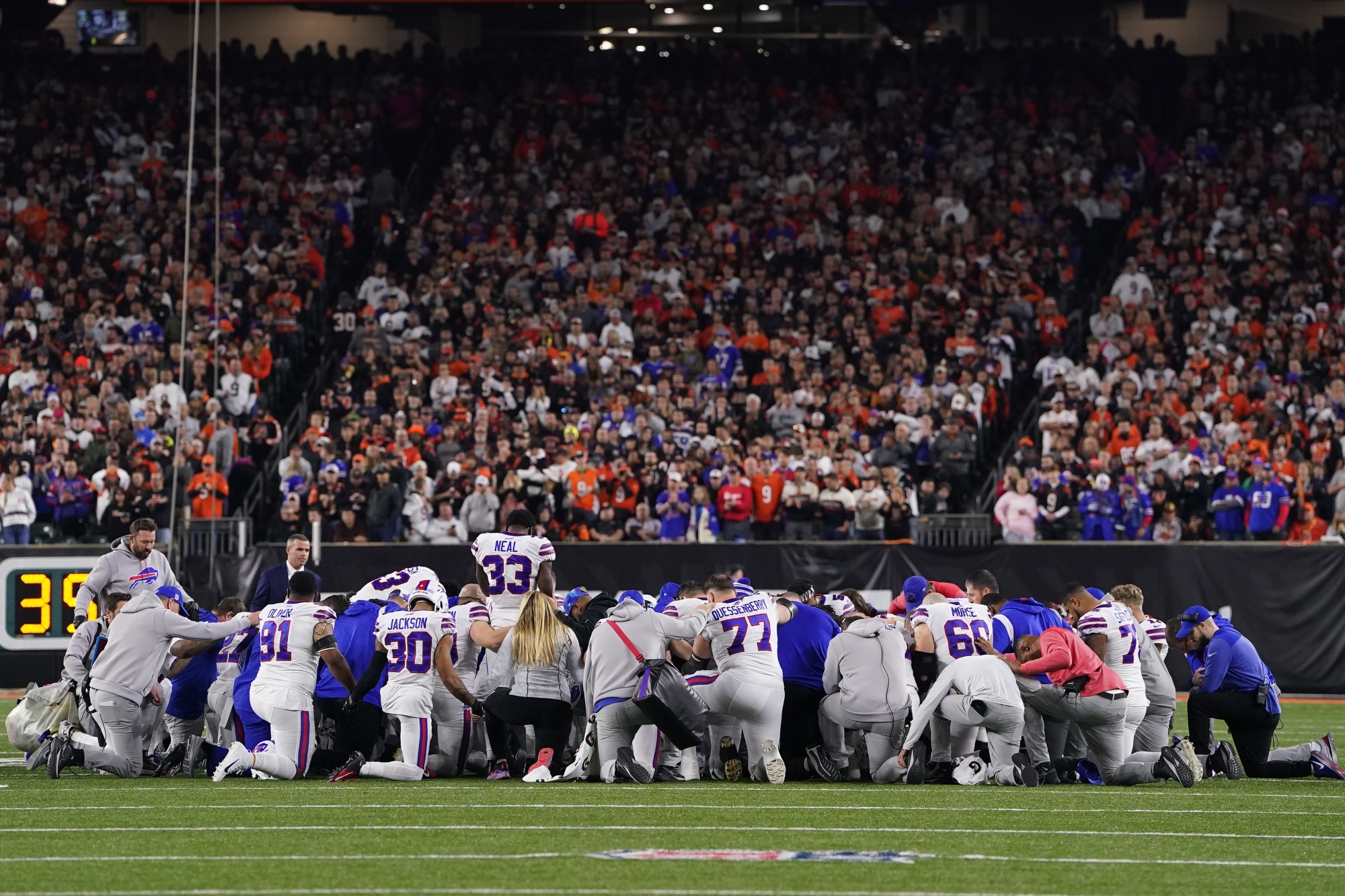 Buffalo Bills players huddle on the field after Damar Hamlin collapsed on the field on January 2.