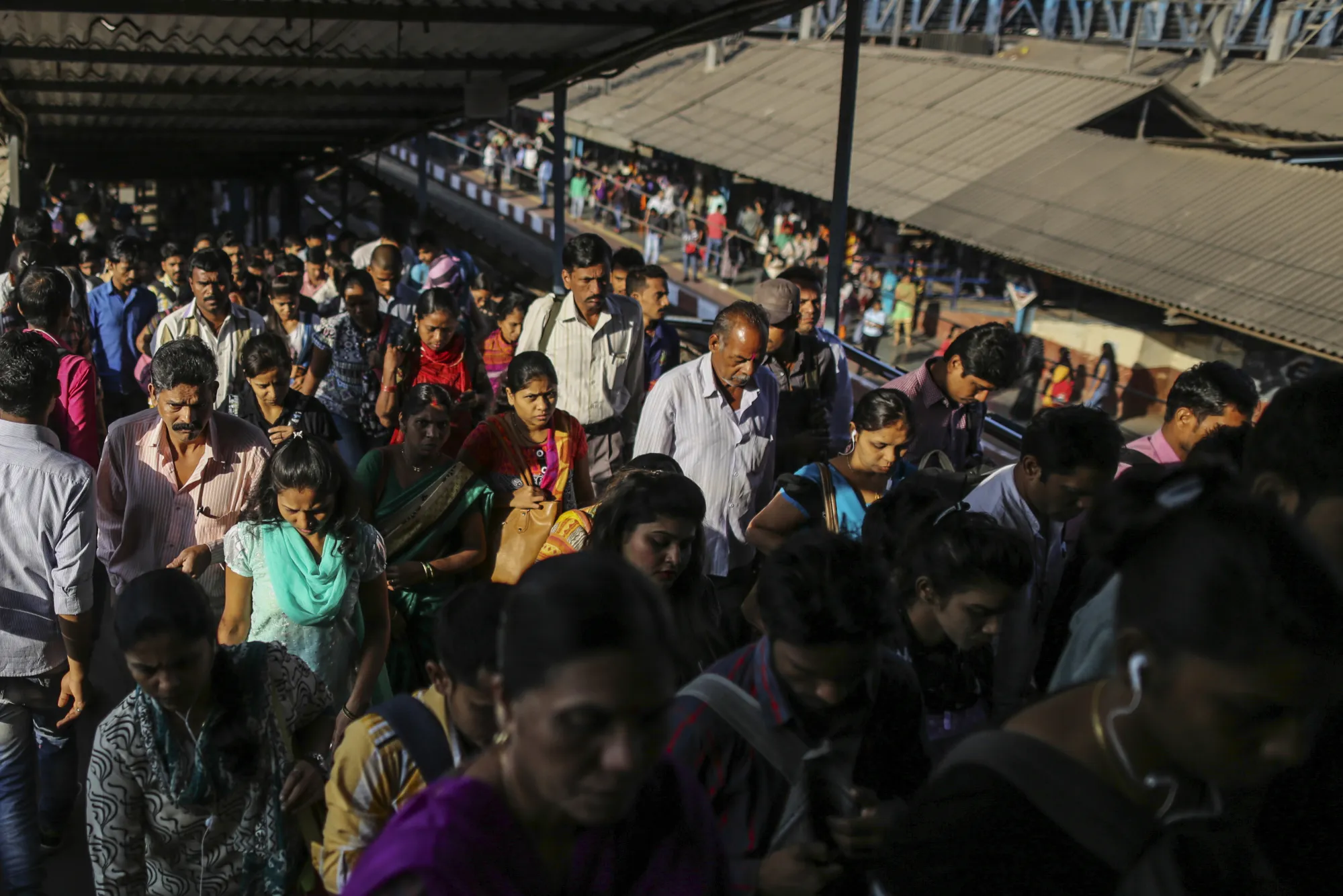 Commuters walk along a bridge at the Kurla railway station in Mumbai, India, on Saturday, Jan. 28, 2017. India's Finance Ministry will recommend bold tax reform to ensure that Prime Minister Narendra Modi's growth-crimping cash ban wasn't in vain, people familiar with the matter said.