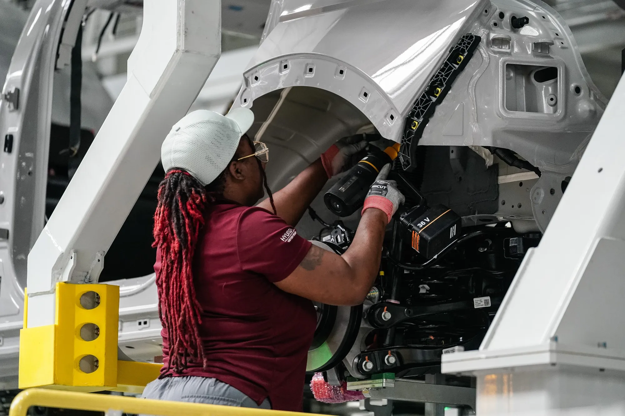 A worker assembles a vehicle on the production floor at an electric vehicle manufacturing facility in Ellabell, Georgia.