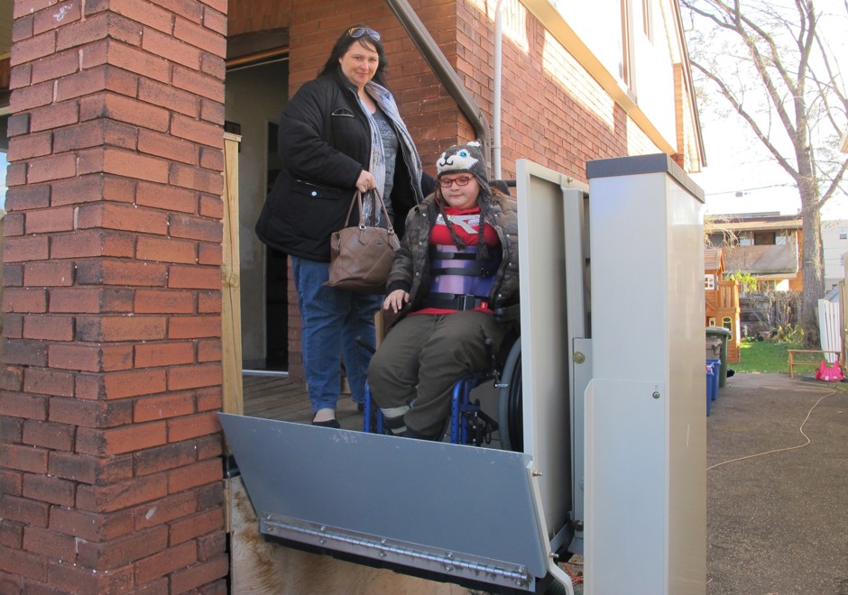 In this Nov. 21, 2017 photo, Jodi Dean helps her wheelchair-bound daughter Madison, who suffers epilepsy and severe osteoporosis, on an elevator as they leave home for a doctor's visit in Hamilton, Ontario, Canada. The mother of three received her first basic income check last month and said the extra money gave her family &quot;the breathing room to not have to stress to put food on the table.