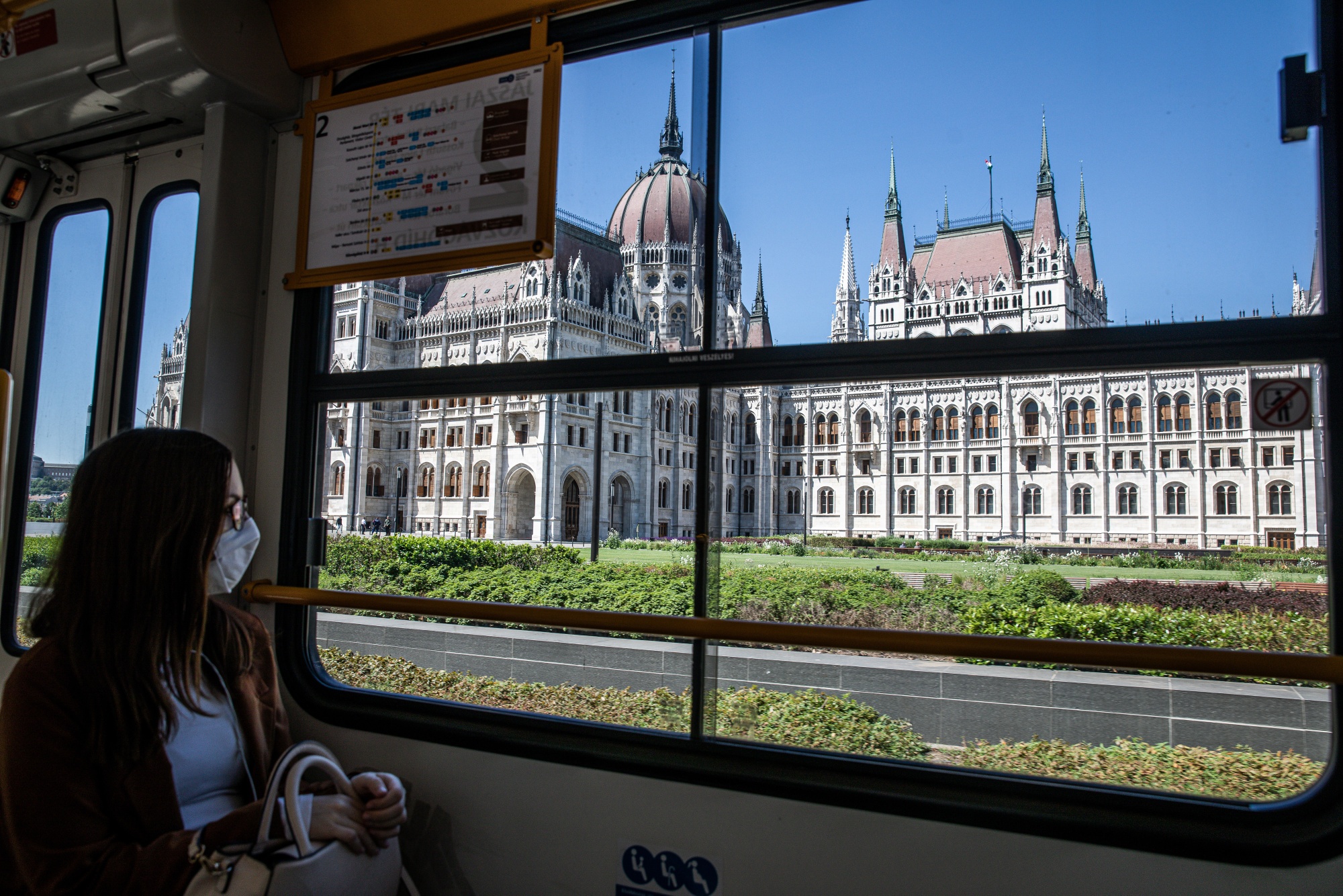 A passenger wearing a protective face mask travels past the parliament building on a tram&nbsp;in Budapest. The coronavirus pandemic has pushed the Hungarian economy into a record recession.