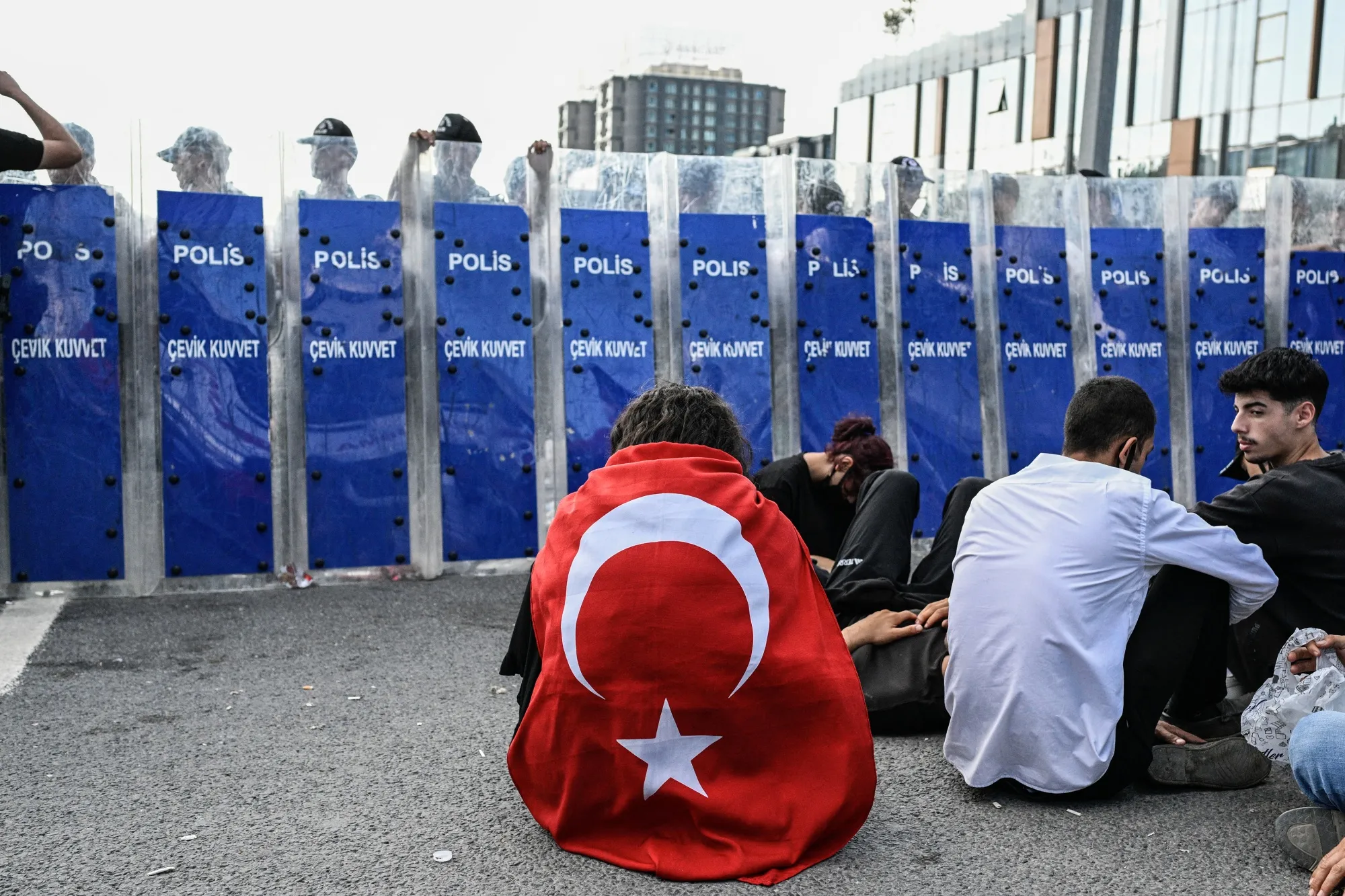 A protester wrapped in a Turkish national flag sits in front of Turkish riot police officers during a demonstration in Istanbul, on Sept. 8.