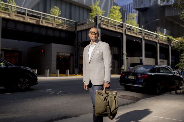 A portrait of Sean Hudson holding a briefcase outside an office building.