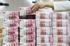 An employee arranges genuine bundles of Chinese one-hundred yuan banknotes at the Counterfeit Notes Response Center of KEB Hana Bank in Seoul, South Korea, on Monday, Aug. 14, 2017. China's factory output and investment slowed somewhat in July, according to data released today, yet the yuan appeared not to take the data as negative, if in fact it's paying attention to it at all.