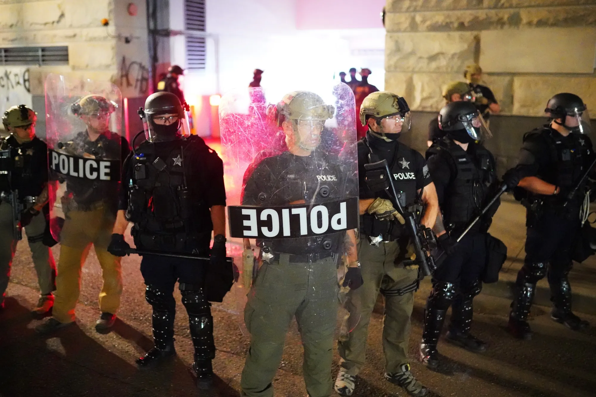 Federal officers guard the rear entrance to the Mark O. Hatfield U.S. Courthouse early in the morning on August 2, 2020 in Portland. A new lawsuit questions the legality of the deployment.&nbsp;
