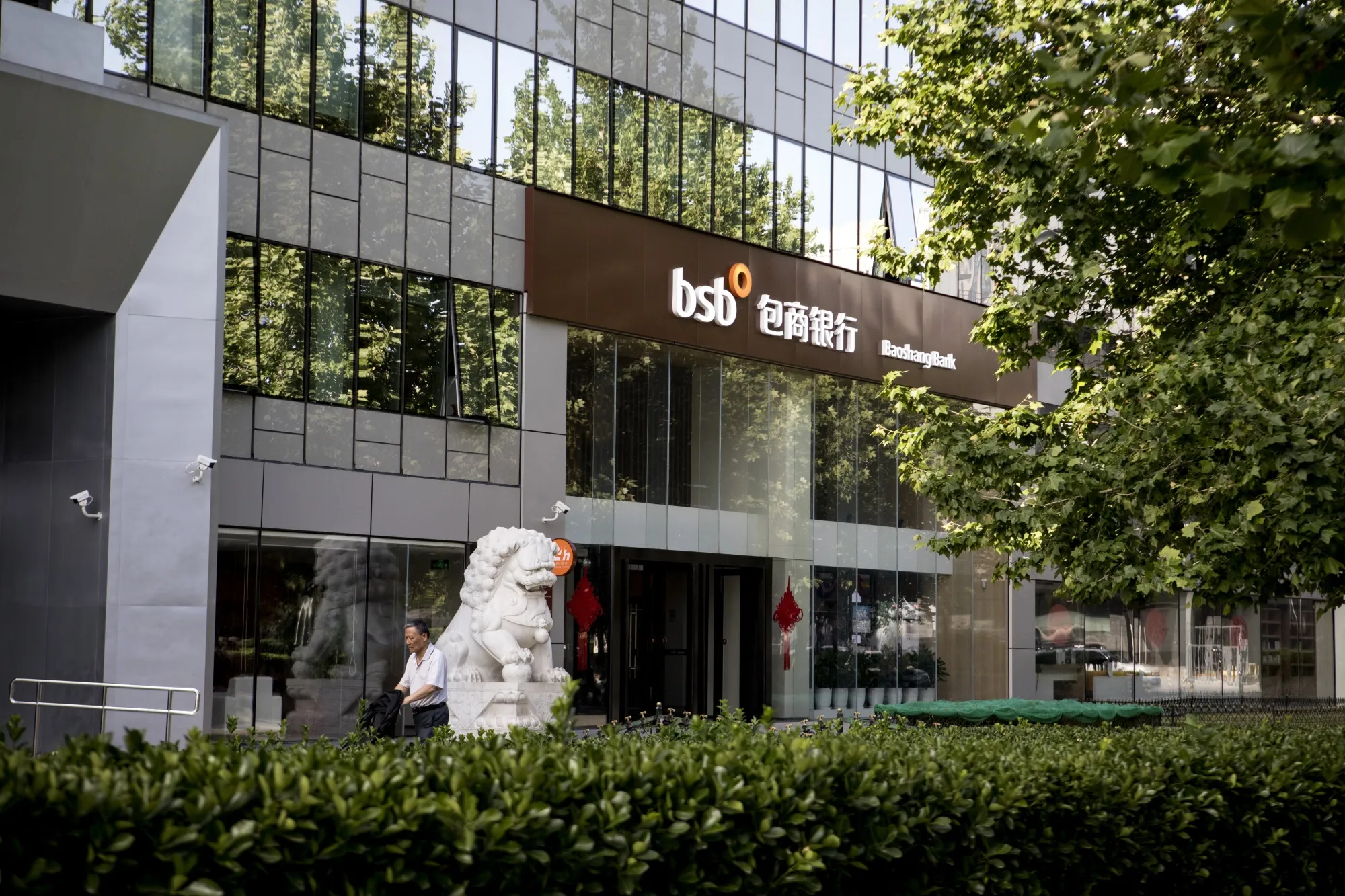 A pedestrian passes in front of a Baoshang Bank&nbsp;branch in Beijing on May 28, 2019.
