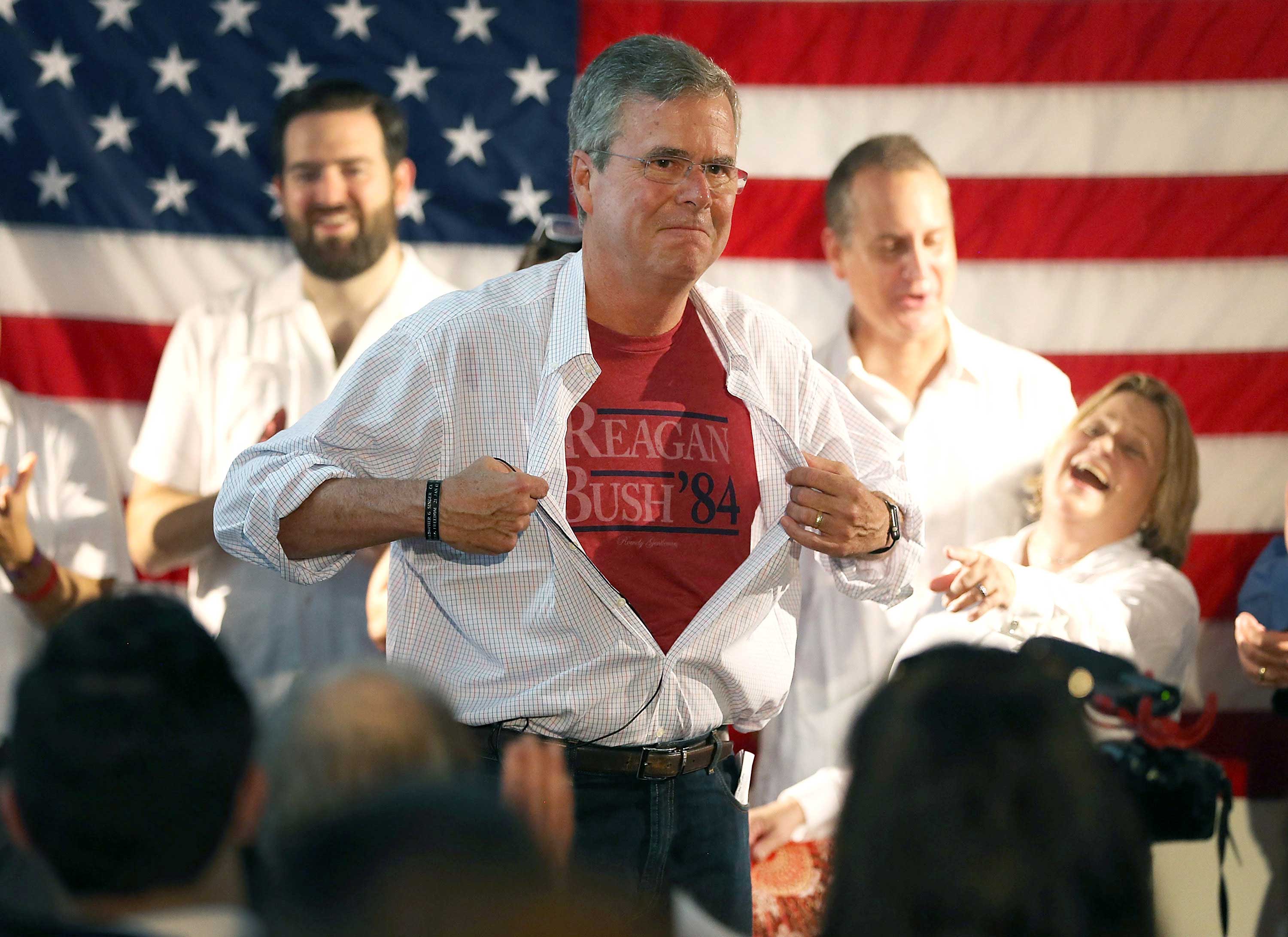 Jeb Bush shows off a Reagan/Bush '84 T-shirt as he speaks during a Miami field office opening on Sept. 12, 2015.
